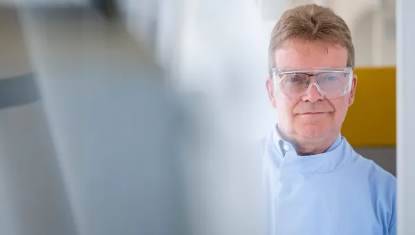 Scientist wearing safety goggles whilst working with lab equipment
