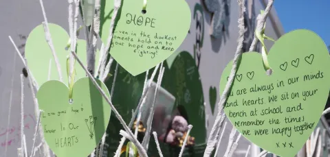 Green paper hearts with mesaages of rememberance for Grenfell Tower victims hearts with