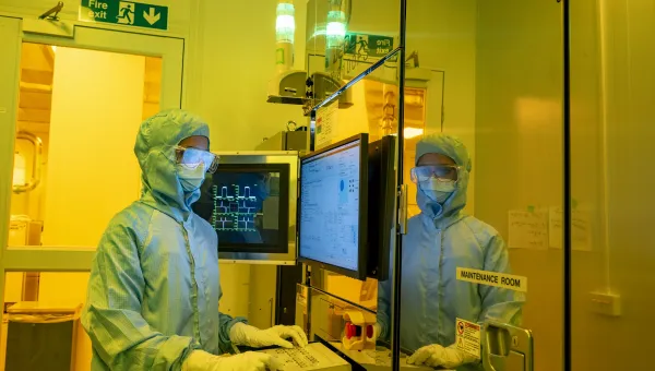 A woman standing near the computer in a laboratory