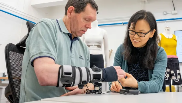 A patient wearing a forearm support receives therapy on his hand