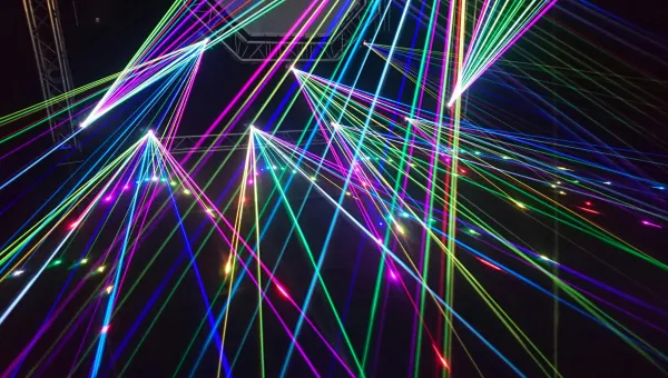 Colourful laser beams intersecting against a dark background.