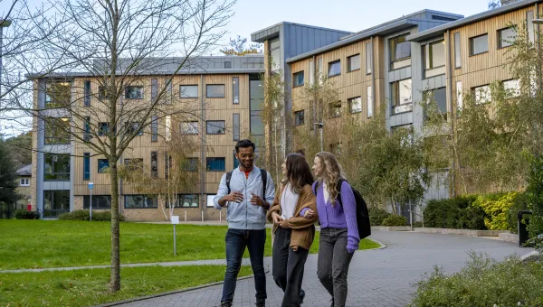 Three students walking outside halls of residence