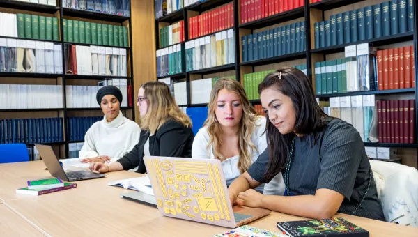 Students sat at table in library