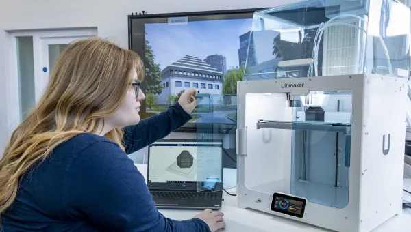 A student inspecting the finished construction of her latest 3D printed object.
