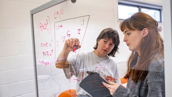 Languages and linguistic students writing phonetic symbols on a board
