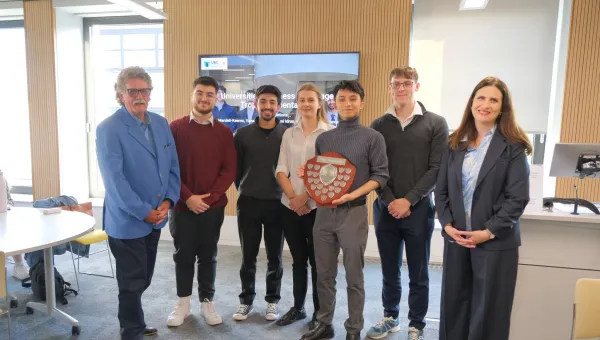 Undergraduates from the Southampton Business School standing in a line with the winners shield at the 2025 Universities Business Challenge.
