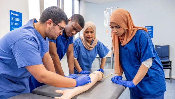 Fahmia and other student doctors studying an arm