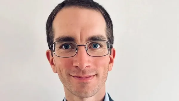 Matthew Blunt, looking directly at the camera in a navy suit with a light blue shirt.