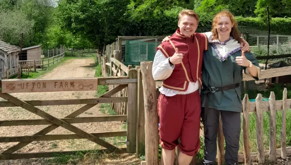 Krzysztof and Joanna standing next to a gate wearing medieval costume