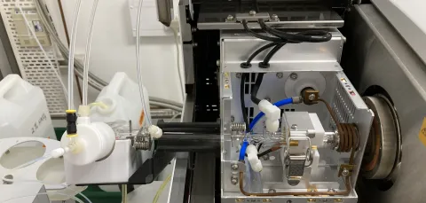 Laboratory instrument with open compartment showing tubes and components.