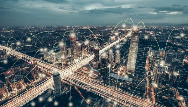 Beijing skyline at dusk with illuminated roads and buildings, overlaid with digital lines symbolizing connectivity.