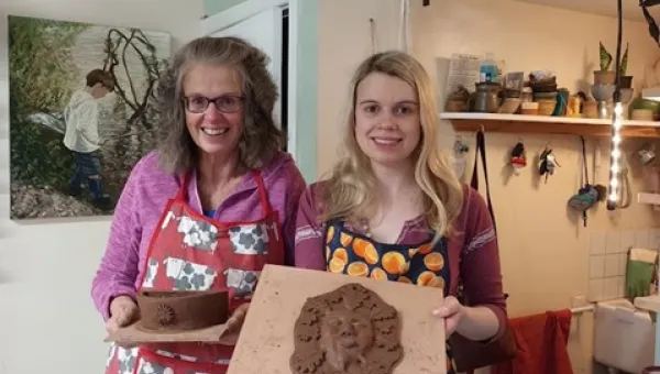 Lara Graham and her mum Nicky stood in their craft room, proudly displaying their terracotta ceramic creations.