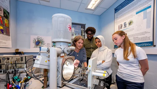 Students gather round a demonstration of a complicated medical imaging machine