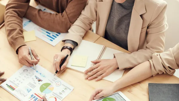A group of people sitting at a table working on papers
