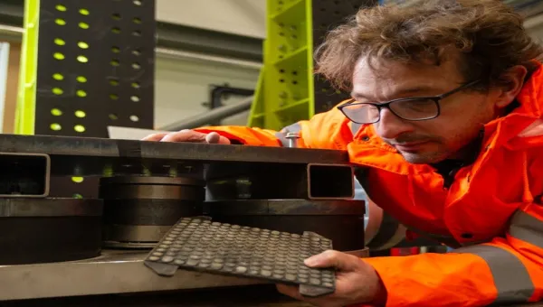 Researcher inspecting a vibration testing rig in the VibSim laboratory