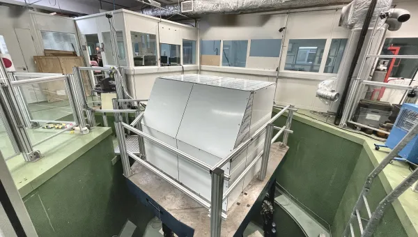 Large vibration testing facility with an enclosed test chamber mounted on a vibration platform inside a laboratory