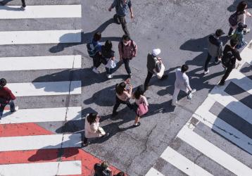 People crossing a busy pedestrian crossing