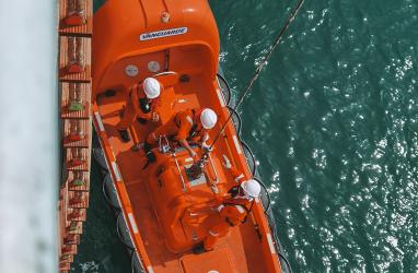 Aerial view of a lifeboat at sea next to a ship