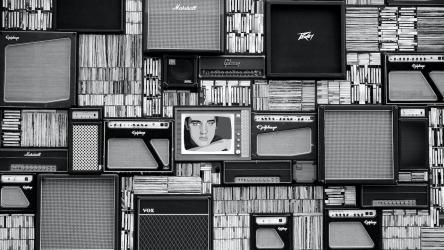 Image of lots of different media, including books, televisions, speakers, and radios.