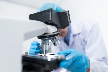 Image of a medical researcher using a medical microscope.