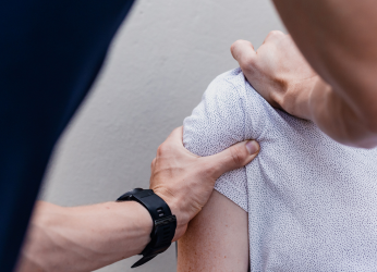 Unsplash image of a physiotherapist manipulating a patient's shoulder muscles