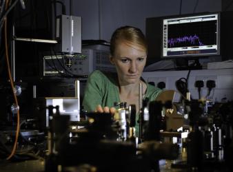 Professor Anna Peacock at work surrounded by equipment in the photonics lab