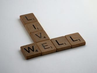 Wooden Scrabble pieces spelling out the words Live Well