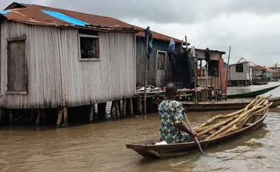 A resident of Ganvie stilt village in Benin navigates a boat through water