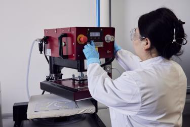 A woman researcher using a machine at the e-textile laboratory