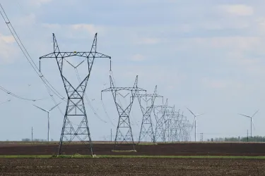 Transmission towers and wind turbines on a field