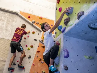Students climbing indoor climbing wall. 