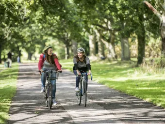 Students cycling on Southampton Common on sunny day.