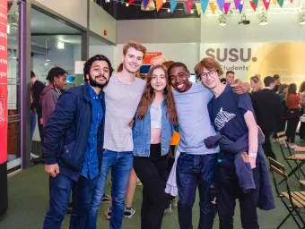 Group of smiling students at SUSU event.