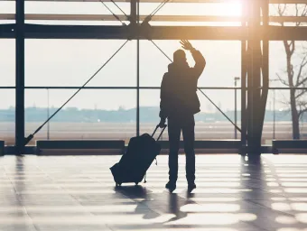 International student waving goodbye at the airport.