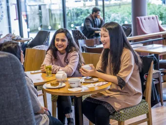 Students talking over coffee inside the Costa on campus.