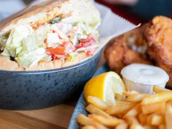 Close-up of roll stuffed with salad and chips on the side.  