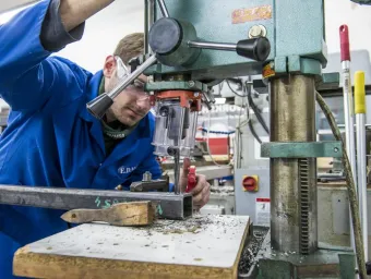 A student uses equipment in the engineering design and manufacturing centre