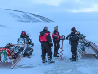 A team of scientists with equipment carrying out field research on a glacier