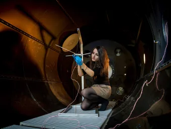 A student checks their experiment in the electric propulsion lab