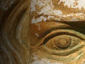 Close up of an ancient artefact face carved in stone