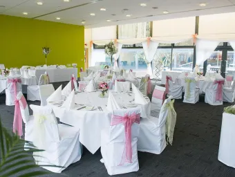 A pre-event photo of the Terrace Restaurant, decorated with wedding sashes on the chairs.