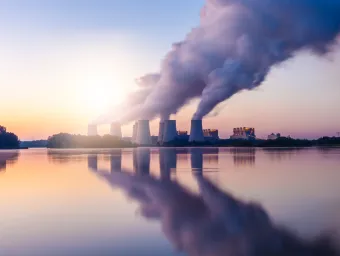 A landscape image of a coal-fired power station expelling pollution into the sky.