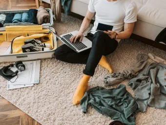 An international student packs their bag, including their passport, to come to the UK