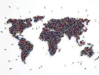 A crowd of people photographed from above, making up a map of the world