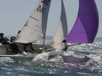 Two sailors in a small boat in rough waters