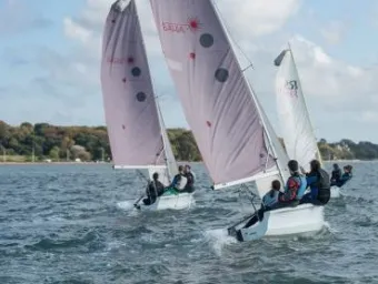 Three sailing boats sailing near the shore