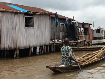 A resident of Ganvie stilt village in Benin navigates a boat through water