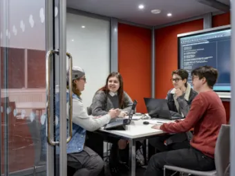 A group of students sit around a table in the maths student centre