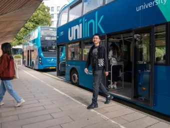 A student alighting a double decker bus at the University of Southampton's Highfield campus.