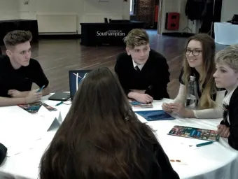 A group of Year 10 students sitting around a table discussing an activity.